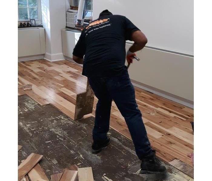 Team member removing damaged flooring.