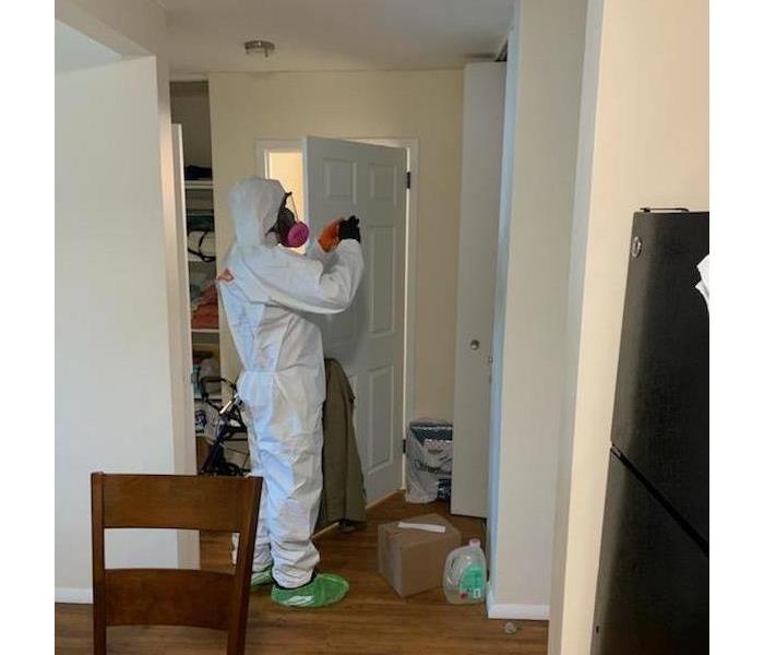 a man in a white suit cleaning a door