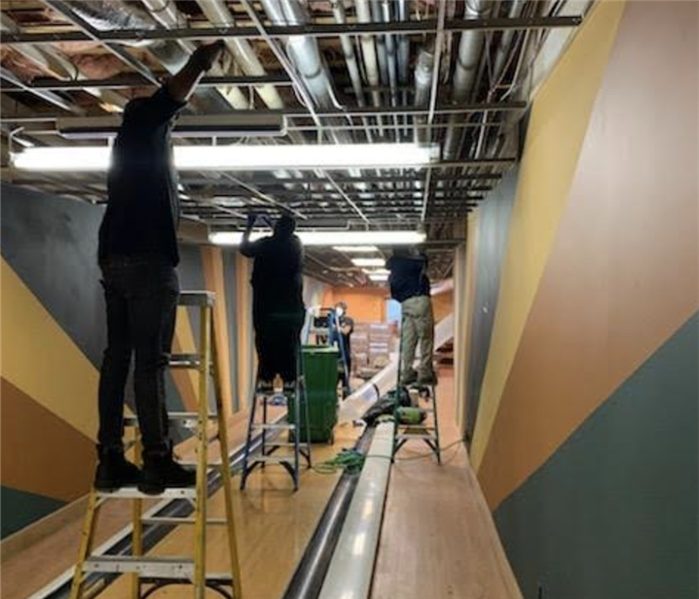 workers working on ceiling of a basement