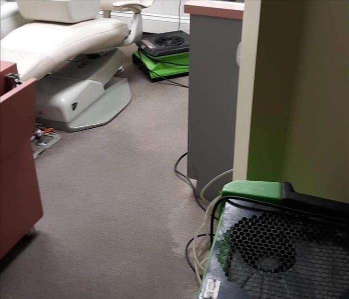 Drying equipment and wet carpet in a doctor's office.