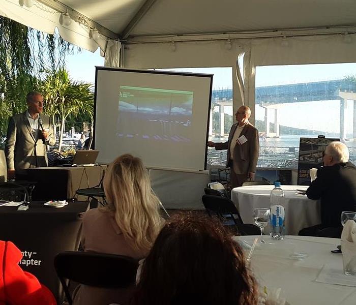 an event with several tables and people gathered around a powerpoint presentation