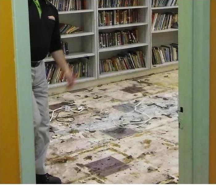 A SERVPRO professional mitigating damage to a library after a storm.