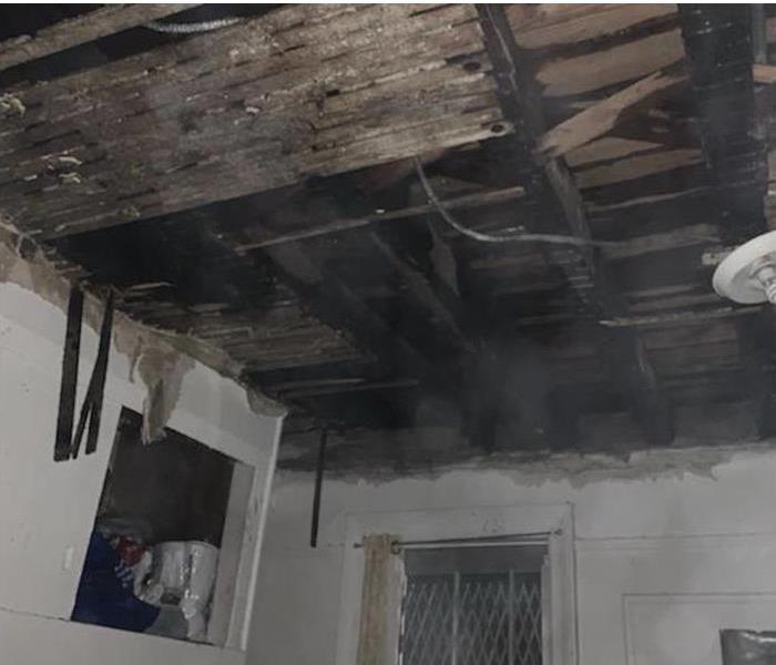 A ceiling of a home ruined by fire damage