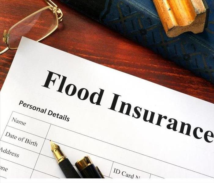 Flood insurance form on a table with a book.