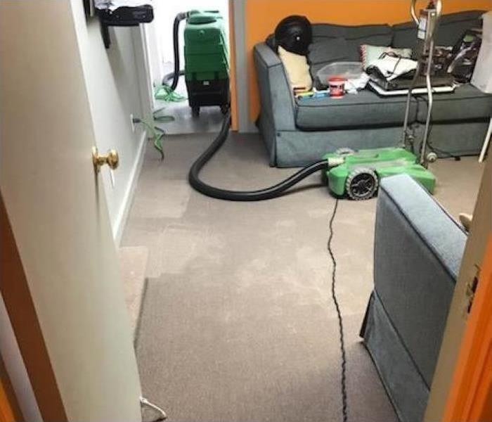 Wet carpet in an office, there is a dehumidifier drying up the affected area